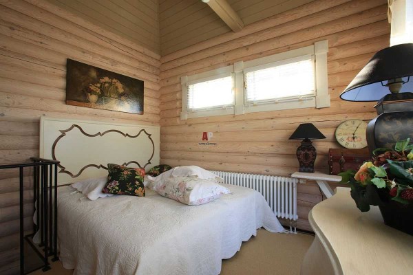 Оформление спальни в домах из бревна ничем не отличается: светлые, спокойные тона и несколько цветовых акцентов